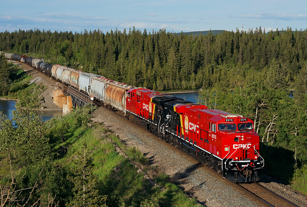 A pair of freshly painted CPKC locomotives lead westbound CP 401 at Seebe, Alberta in nice evening light.