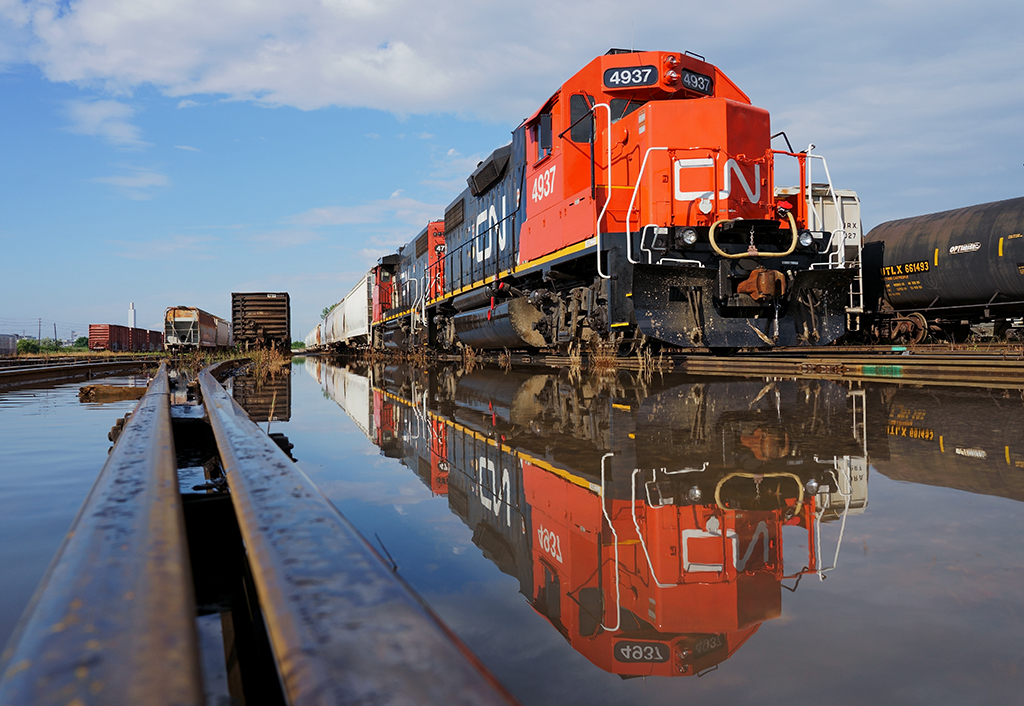 A reflection of today's activity..

While we were supposed to go to Aldershot, we remained on standby as heavy rains pounded the Greater Toronto Area rendering Aldershot Yard closed due to flooding, so basking in the summers afternoon sunlight is the train tied down on track 36 awaiting it's next road assignment.