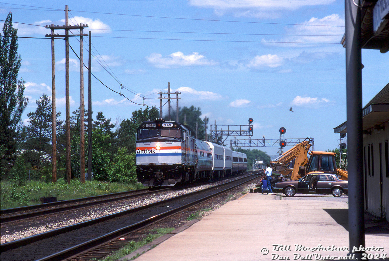 Amtrak F40PH 249 leads joint VIA-Amtrak train #181 "The International" westbound on the CN Oakville Sub into Burlington Station, passing the signals at Brant Street underpass. A pair of unknown railfans bearing cameras get their shots of the consist near the platform edge. Today's consist is an Amtrak F40PH, a single Amfleet car, two Horizon cars, and three VIA LRC cars.

Bill McArthur photo, Dan Dell'Unto collection slide.