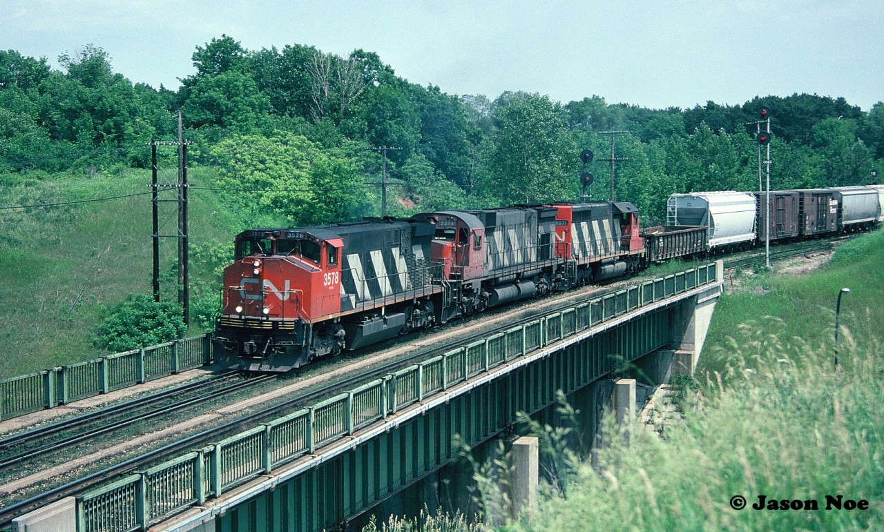 CN M-420(W) 3578, M-636 2314 and SD40 5071 lead a westbound over the Highway 403 bridge as it begins its trip over the CN Dundas Subdivision at Hamilton West, Ontario.