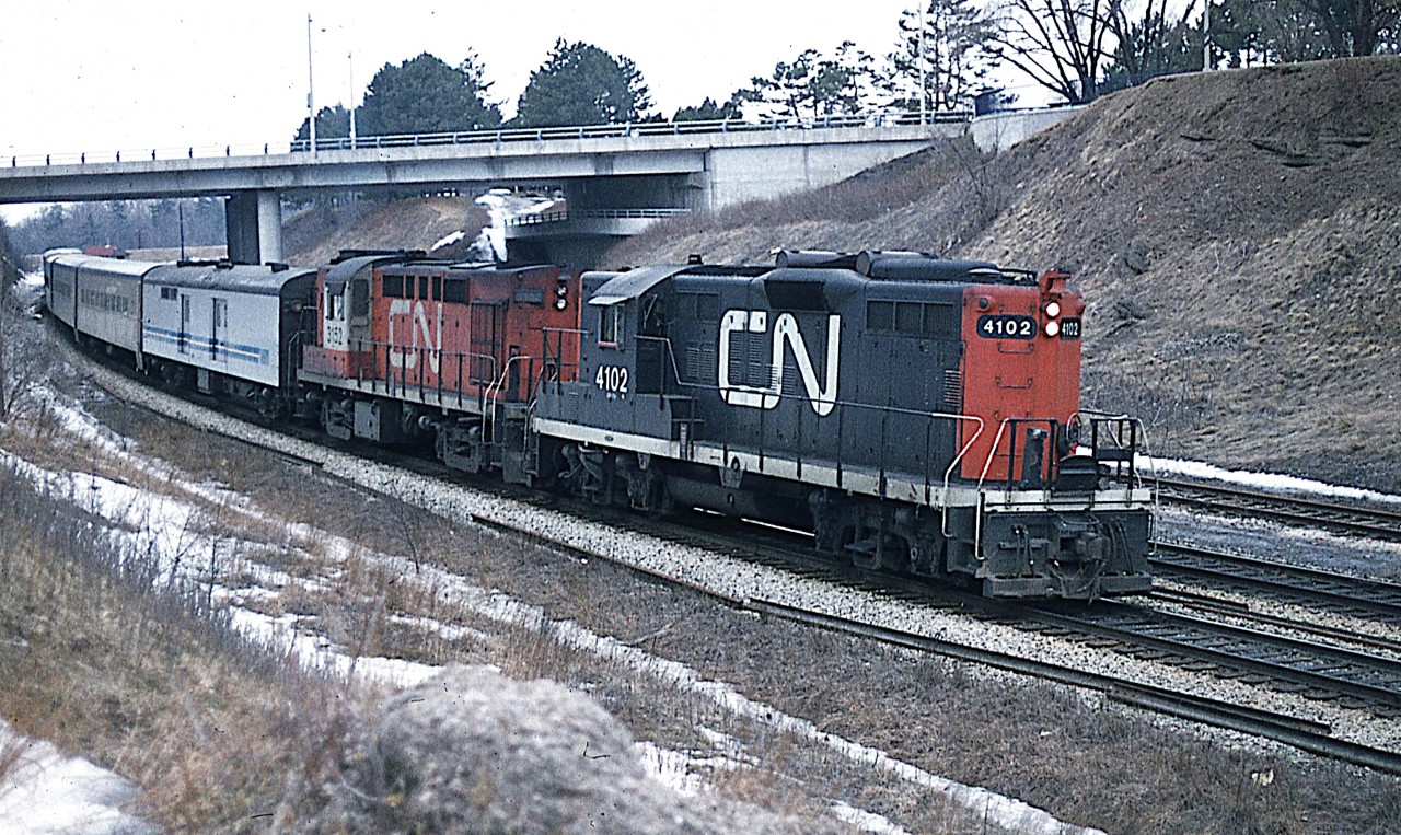 Typical cool & dull February morning at the Junction.  But still worth being there.  I do not recall if I had yet heard of the new VIA corporation that was in the planning stages, but still, anything rolling along the rails was fair game for the old Pentax K-1000 back in the day.
Here we see CN 4102 and 3152 coming 'off the hill' on its' way to Toronto.  In the background one can barely make out the rather large wayside MoW building that used to be at Hamilton West.