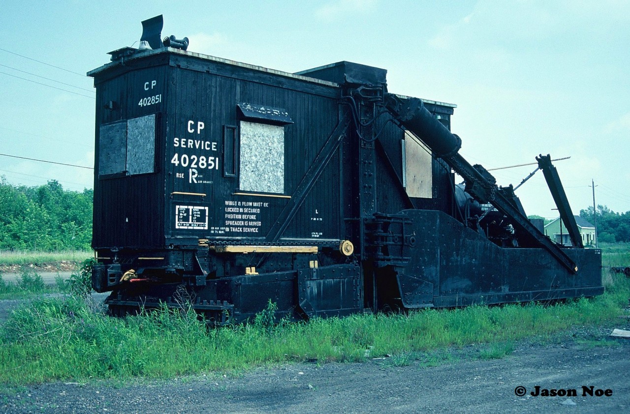 Long stored CP 402851, which is a wooden cab Jordan spreader with ice cutters is pictured sitting in the CP yard at Smiths Falls, Ontario. During the 90's photos show that this spreader spent a significant time in the same location in Smiths Falls. It's final disposition is unknown, unless someone on this site has information on it's eventually status.