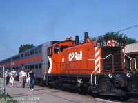 Not just for branchline work, the little GMD SW1200RS was a versatile model used in mainline freight, branchline, yard switching, hump, local, and even passenger service: CP 8131 is seen with two Canadian Vickers gallery cars on the "Yo-Yo" (the all-day back-and-forth Montreal commuter train) unloading at Montreal West Station. Typical consist was two cars with one unit was assigned, and often it was an SW1200RS. According to the late Bruce Chapman it was typically an 8131-8171 series unit equipped with 24RL brakes. Since the Canadian Vickers cars had their own onboard HEP generators, using a freight unit such as an RS18 or SW1200RS wasn't a problem.<br><br>Many crews tended to prefer those 24RL equipped units over the earlier 6SL brake setups still on 8100-8130. According to Bruce, one time an earlier 8100-8130 series unit was assigned to that run, and the engineer (who was "a tad portly") had a fit about running it, as the larger 6SL brake handle setup interfered with his girth.<br><br>As part of the SW rebuild program, most of the upgraded SW1200RSu units in the 1200-series received modern 26LUM brakes.<br><br><i>Original photographer unknown (duplicate slide), Dan Dell'Unto collection slide.</i>