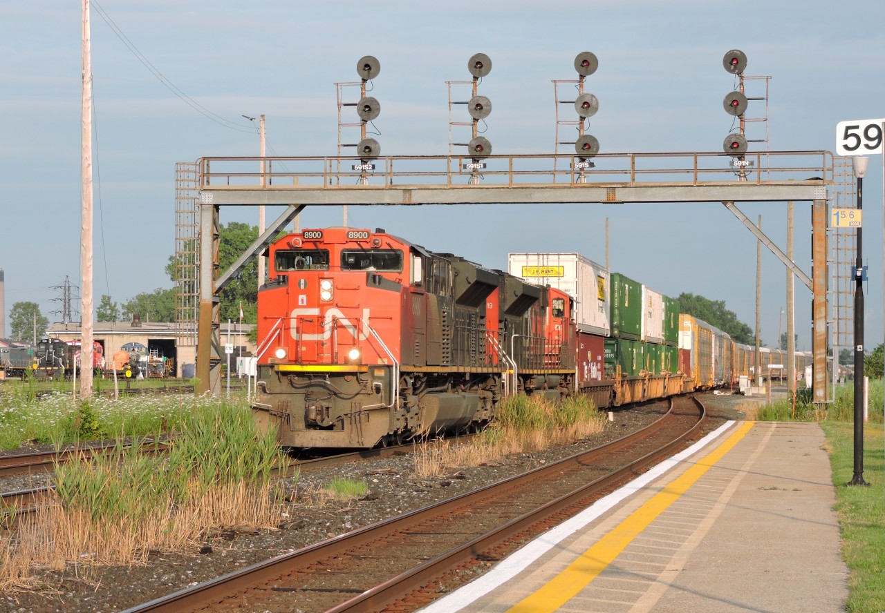 CN SD70M-2 8900 leads train 122 past the station at Sarnia and under the signal bridge, the signals and bridge were installed when the new St. Clair tunnel was opened in 1995 allowing for seamless movements of double stack and over height cars to pass beneath the St. Clair river as seen in this train.