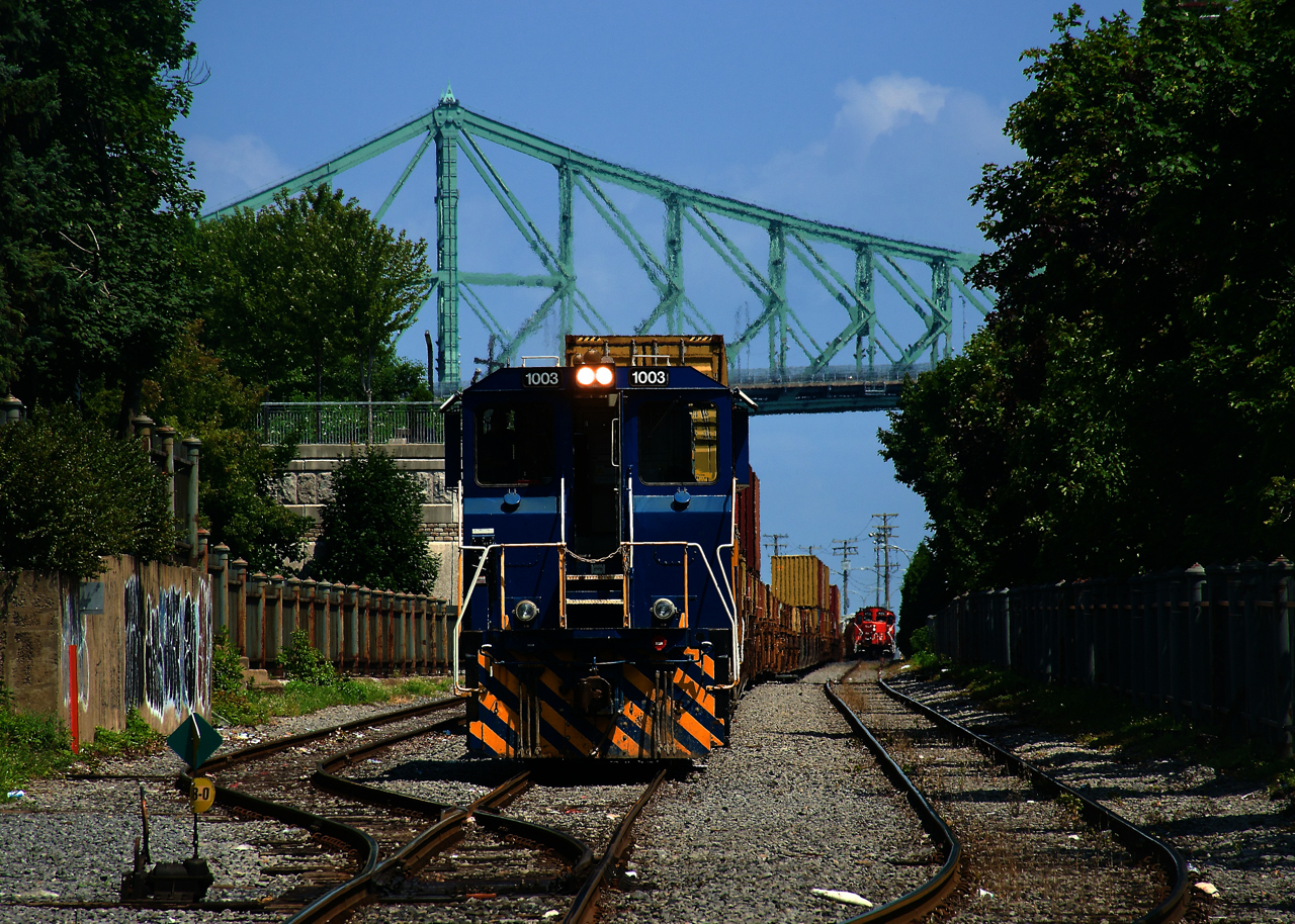 A Port of Montreal switcher is shoving back with stacks as CN 500 in the distance gets ready to leave the port.