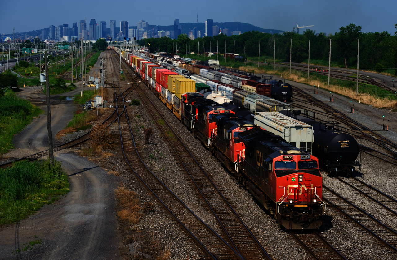 CN 120 is passing through Southwark Yard, with the skyline of downtown Montreal behind it.