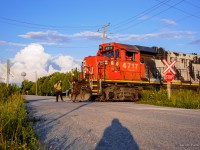 CN L584's brakeman gives a thumbs up with coffees in hand and timbits already on board as he prepares to join the rest of the crew in the cab of 4717.  With work at the interchange yard, Agrico, and Formet done, the crew can sit back and relax as they roll into the setting sun.