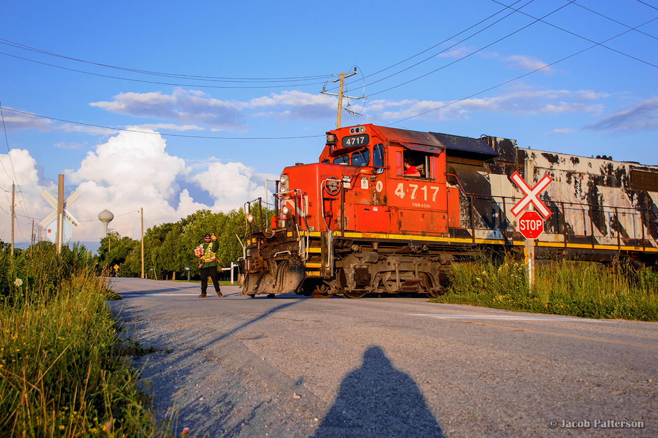 CN L584's brakeman gives a thumbs up with coffees in hand and timbits already on board as he prepares to join the rest of the crew in the cab of 4717.  With work at the interchange yard, Agrico, and Formet done, the crew can sit back and relax as they roll into the setting sun.