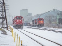 An afternoon snowfall has kicked up in Hamilton, where jobs from both class 1s are seen around the interchange.  At right, CN's 0700 job is lifting traffic from CP, along with cars from Stelco, Mana, and Parkland Fuels, while TH11 returns down the Belt Line from Kinnear, bound for Strathearne Yard.