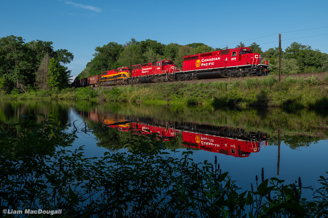 On a gorgeous July evening, CP 6011 leads loaded ballast train GPS-14 through the causeway at the north end of Long Lake in Bala, ONT. Making pretty good time from a noon departure at Cartier, they're doing every bit of track speed to get to Buckskin to meet northbound manifest train #421.