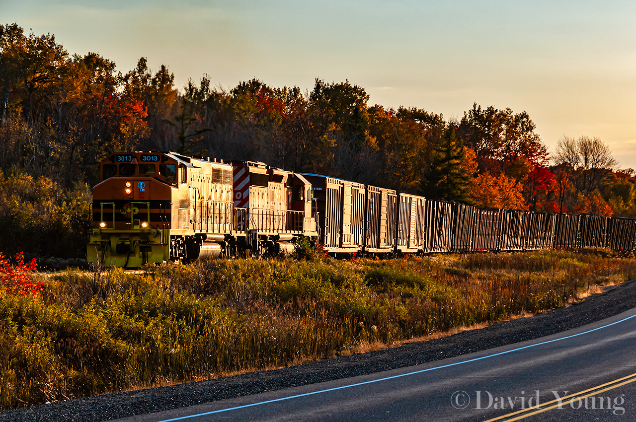 A chance encounter along Highway 17 with the eastbound Huron Central freight. HCRY GP40-2W 3013 and leased CP SD40-2 6030 trundle 34 car train of forest and steel goods along at sunset.