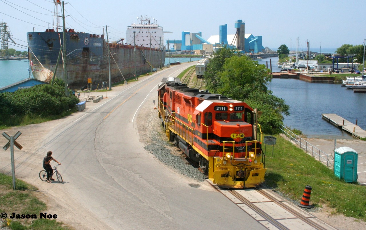 It’s an absolute stunner of a summer day as Goderich-Exeter Railway train 581 is observed completing its switching duties at the picturesque Goderich, Ontario harbor. Powered by veteran GP38-2’s RLHH 2111 and HESR 3510, the train made two runs down to the harbor on this afternoon to lift and set-off sizeable cuts of salt hoppers. While it once ran daily, GEXR 581 is now operating as required to Goderich from Stratford on the Goderich Subdivision.