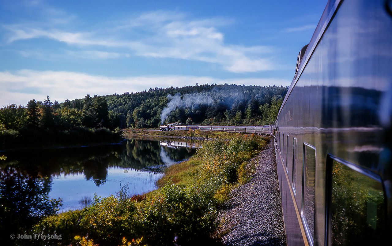 Peering down the train from the rear platform of buffet-lounge car, "Burrard," Extra CNR 6167 west is getting back underway at mile 145 of the Beachburg subdivision, about halfway between Lake Traverse (mile 140), and Radiant (mile 151) as the UCRS special from Ottawa to North Bay cuts across the wilds of northern Ontario, alongside the Pettawawa River.

The weekend of September 13 - 15, 1963 marked a massive undertaking by the Upper Canada Railway Society, a 692.2 mile excursion from Toronto - Ottawa - North Bay - Temagami - Toronto, with seventeen coaches behind CNR 6167.  With the train having run overnight from Toronto - Ottawa on the 13th, the train turned west and departed the nation's capital early on the 14th.  6167 would be removed at North Bay, with ONR FP7s 1521 and 1511 handling the train to Temagami overnight.  The consist returned to North Bay on the morning of the 16th, with 6167 taking over once again for the return to Toronto.

Further information will be detailed in upcoming posts, but can also be found in the December 1963 UCRS news letter.


Scan and editing by Jacob Patterson.