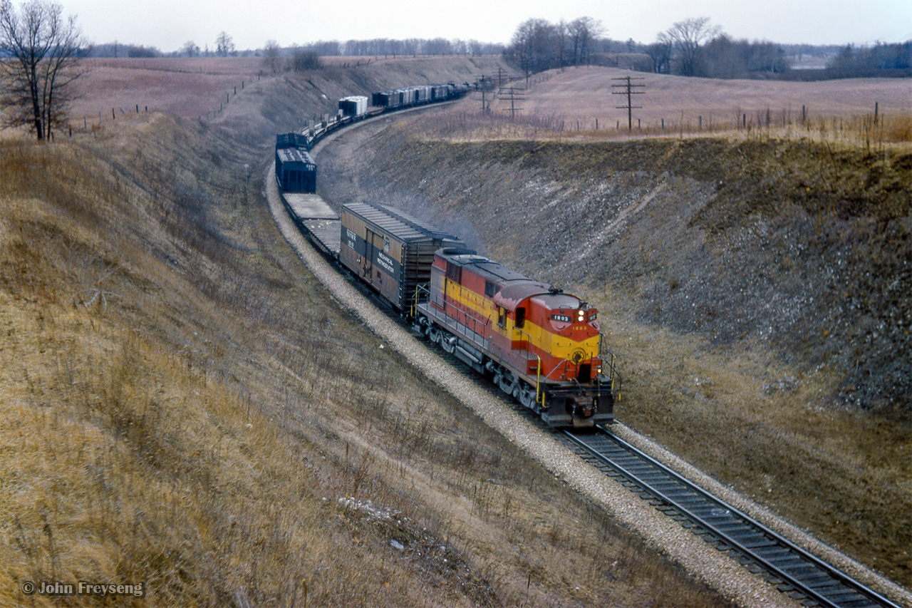 Lake Superior & Ishpeming 1803, and ALCO RSD12 on lease to the CPR, leads an eastbound timetable freight downgrade just east of Orr's Lake through Barrie's Cut.Scan and editing by Jacob Patterson.