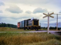 A southbound wayfreight behind GMD SW1200RS 1207 hustles south with a single NYC boxcar in tow at Franklin Road crossing, long since removed.<br><br><i>Scan and editing by Jacob Patterson.</i>