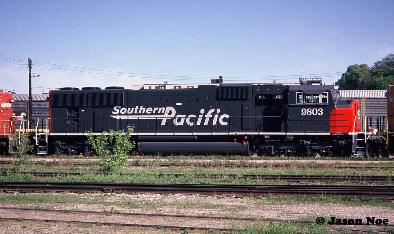 Just off the assembly line, Southern Pacific SD70M 9803 is viewed gleaming fresh as its being lifted by a westbound at CP’s Quebec Street yard in London, Ontario. SP 9803 was part of a 25 unit order that was manufactured at GMDD’s London plant during June-August 1994. Also coupled to the SP unit was Burlington Northern SD70MAC 9460, which left the GMDD facility in primer for the US.