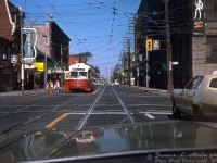 Cruising along Queen Street West on a sunny afternoon finds TTC PCC 4687 (an A12-class secondhand ex-Cleveland car built by St. Louis Car Co in 1946) stopping to let off a group of passengers at the corner of Queen Street West and Shaw Street, operating on a westbound Queen run heading for Humber Loop. Note the "New" Corvale Restaurant on the left (open since the early 60's at least). The highrises of downtown Toronto await in the distance, but a turn right down Shaw would find the photographer behind the wheel in the still-industrial Liberty Village/Parkdale area (the building on the right is part of farm implement manufacturer Massey Ferguson's sprawling industrial complex). 
<br><br>
Today, the older storefronts and industrial buildings of gritty 70's "West Queen West" shown here have all been replaced with glass highrises, and more than a few extra tall buildings line the downtown skyline in the distance. Newer Bombardier LRV's have replaced the ALRV/CLRV fleet that replaced much of the PCC's in the 80's.
<br><br>
<i>James L. Alain photo, Dan Dell'Unto collection slide.</i>