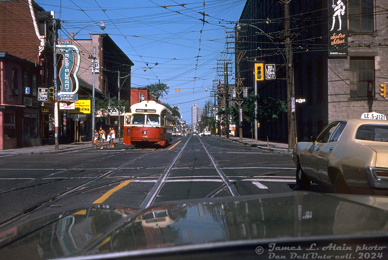 Cruising along Queen Street West on a sunny afternoon finds TTC PCC 4687 (an A12-class secondhand ex-Cleveland car built by St. Louis Car Co in 1946) stopping to let off a group of passengers at the corner of Queen Street West and Shaw Street, operating on a westbound Queen run heading for Humber Loop. Note the "New" Corvale Restaurant on the left (open since the early 60's at least). The highrises of downtown Toronto await in the distance, but a turn right down Shaw would find the photographer behind the wheel in the still-industrial Liberty Village/Parkdale area (the building on the right is part of farm implement manufacturer Massey Ferguson's sprawling industrial complex). 

Today, the older storefronts and industrial buildings of gritty 70's "West Queen West" shown here have all been replaced with glass highrises, and more than a few extra tall buildings line the downtown skyline in the distance. Newer Bombardier LRV's have replaced the ALRV/CLRV fleet that replaced much of the PCC's in the 80's.

James L. Alain photo, Dan Dell'Unto collection slide.