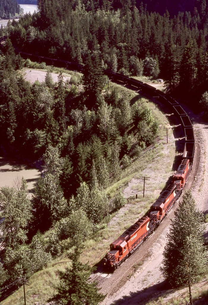 Following CP eastward (compass northward) in the Fraser River canyon from crew-change point North Bend, a gravel road wound forth and back and crossed the Nahatlatch River three miles beyond Chaumox, and just a bit beyond that road bridge, climbed well above the railway, providing relatively easy access to the top of a gravel bank which was ideal for train observation.  Here is an eastward coal empties with CP 5803 and 5861 and one more SD40-2 on the headend (and unseen mid-train remotes) on Wednesday 1987-06-24 heading for next station Keefers and onward to next crew change at Kamloops.

The CPKC bridge over the Nahatlatch River (half a mile west of the photo) is a bit of a walk to access and rather difficult for photos.