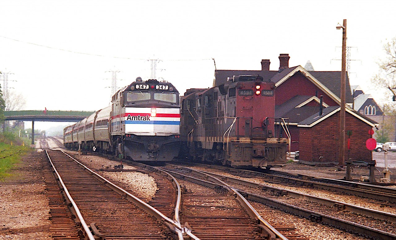 Its one of those hazy foggy mornings we see so often due to the winds off the lake. The local way freight with CN 4594 and 4595 is paused in front of old Merritton station as the eastbound morning AMTK slides by. That is, according to my map, Merritt St bridge in the background.  I've always referred to it as Hartzel Rd but apparently it changes names along the way. If St. Catharines cannot screw your mind up with their street layout, they'll slam dunk you with their road names.
Merritton station burned down in 1994. I don't recall the cause, but suspect it was arson.