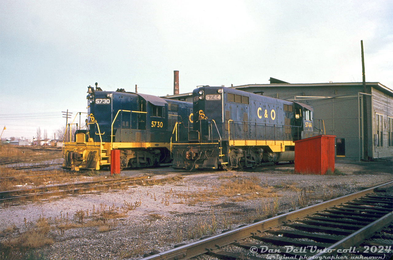 Chesapeake & Ohio GP7's 5730 and 5744 (built by GMD and EMD respectively, in 1951), gleam in the evening light outside the old wooden enginehouse at Chatham in 1970.  Due to tax/duty rules at the time, a handful of US railways including C&O, NYC and Wabash purchased locomotives from EMD's Canadian operation, General Motors Diesel, in London Ontario. C&O acquired units 5720-5738 from GMD (5720-5729 later sold to the New York Central RR for their Canadian operations in 1956, as NYC 5818-5827).  C&O 5744, built by EMD, was one of a handful of US-built GP7's transferred to the C&O's Canadian operations. The Geep fleet worked C&O's lines in southern Ontario for many decades and into the 1980's under CSX, until mass retirement in the mid-80.Original photographer unknown, Dan Dell'Unto collection slide.