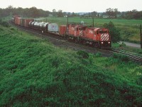 A short CP eastbound is seen at the east siding switch Orrs Lake on the Galt Subdivision powered by C-424’s 4227 and 4201. If memory serves, the photo was taken from atop a large gravel hill. 