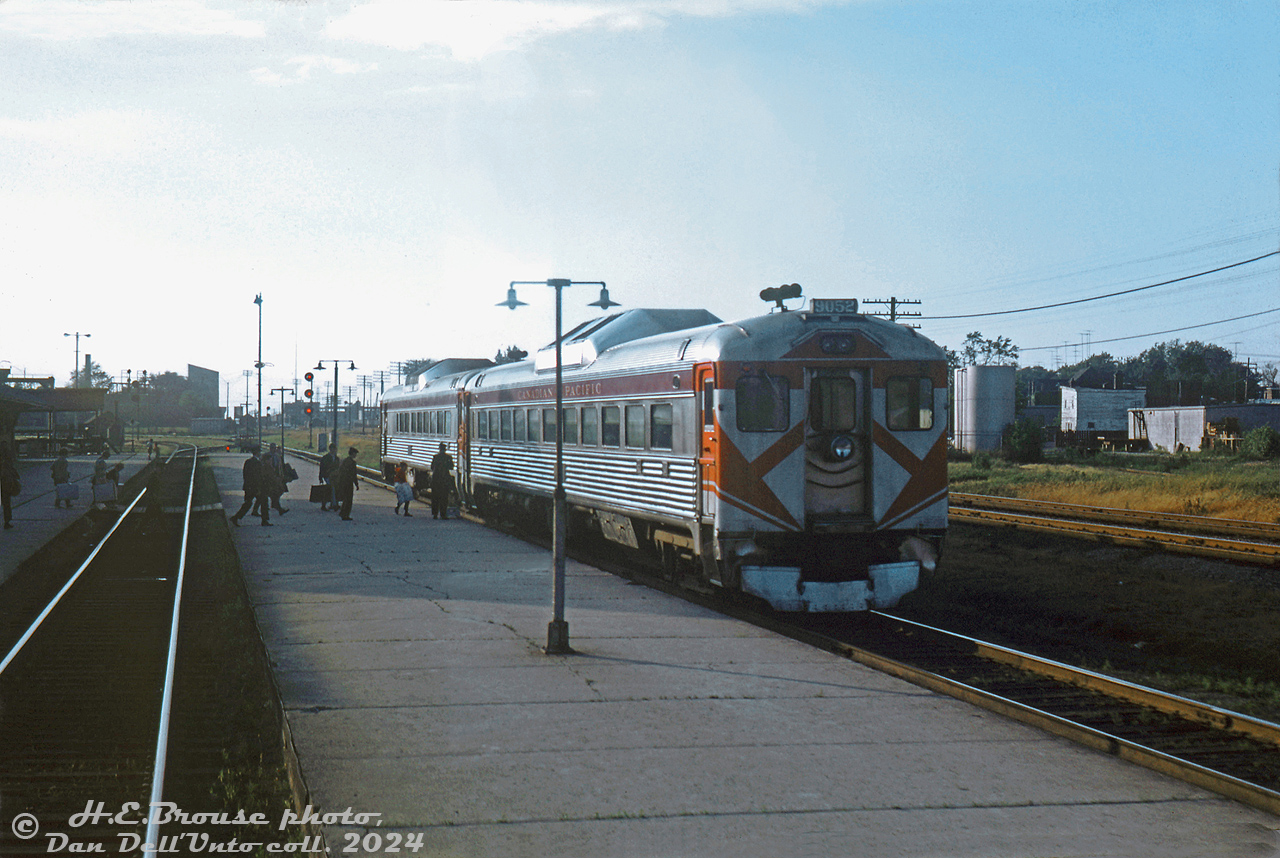 Canadian Pacific "Dayliner" RDC-1 9052 trails a 9100-series RDC-2 on train #337 (Toronto-Windsor), stopped at West Toronto station as passengers cross for the station and board from the center platform. The train is viewed from the rear Park car of train #12, the southbound Canadian, making its station stop at the same time. Timetables suggest #337 was due at West Toronto at 6:40pm and #12 at 5:55pm, so it's more likely #12 was running a bit behind schedule on its long trip down from Sudbury to Toronto. In the distance one can barely make out the connecting track that #12 snaked through to get from the MacTier Sub north of the interlocking diamond to the station platforms here. On the right was the small yard on the S-Yard Lead (the old Bruce Service track, today the West Toronto Railpath).

At this time CP ran four Dayliner runs on the Toronto-Windsor (once Toronto-Detroit) corridor, #337-340, but #339/340 (that replaced the #21/22 in 1964) were discontinued a few months later in 1969. CP trains #337 and #338 became the final remnants of the Toronto-Windsor-Detroit corridor passenger service on the Galt Sub, that once hosted more frequent train service with conventional passenger consists. They made their last runs in early July 1971.

Other photos from the day suggest US-based rail photographer Harold Brouse was on a trip coming back from up the Algoma Central and CP operations up north in the Sault St. Marie area, and was taking #12 southbound (with FPA2 4083 & an RS10 as power) back to Toronto, possibly to connect with the CP-TH&B Budd car run back to the US.

H.E. Brouse photo, Dan Dell'Unto collection slide.