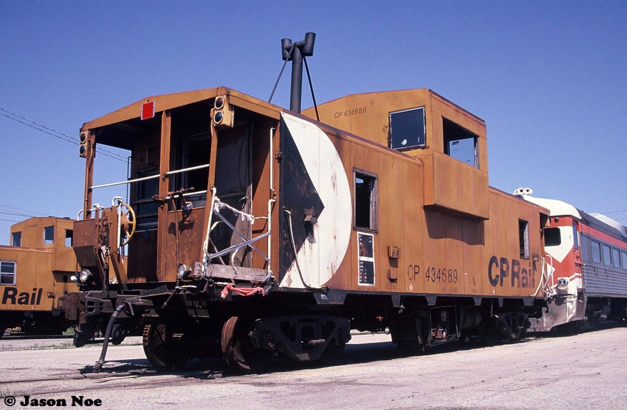 During a pleasant summer morning, damaged CP caboose 434689 and a retired RDC are pictured sitting by the caboose shop in CP’s Toronto Yard.