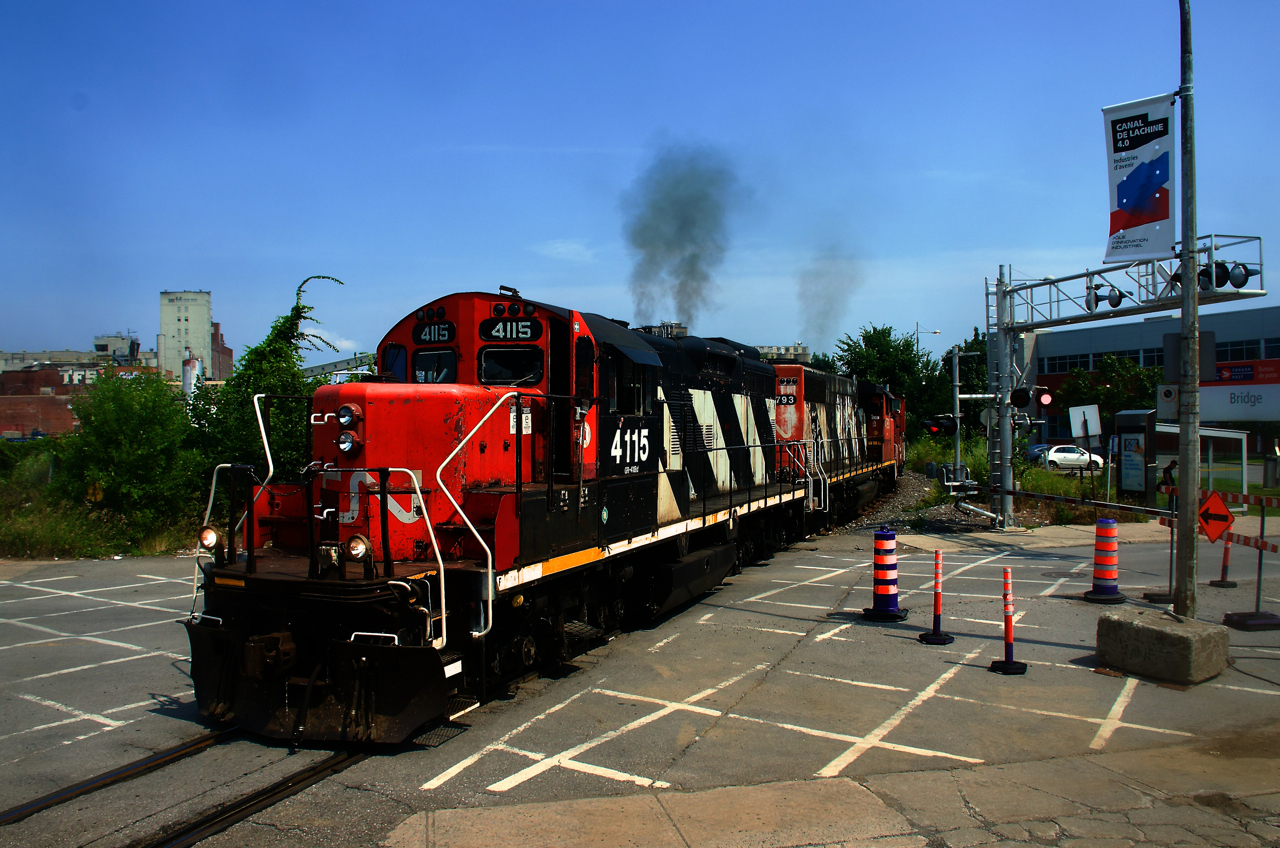 CN 4115 lets out some smoke as CN 500 crosses Bridge Street, nearly back at Pointe St-Charles Yard after a run to the port.