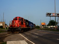 CN YRP002 has a beat up GP9 leading as it crosses Marien Avenue with 17 cars for a few clients.