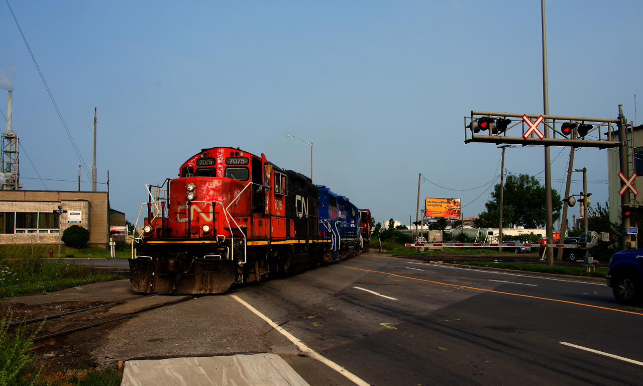 CN YRP002 has a beat up GP9 leading as it crosses Marien Avenue with 17 cars for a few clients.