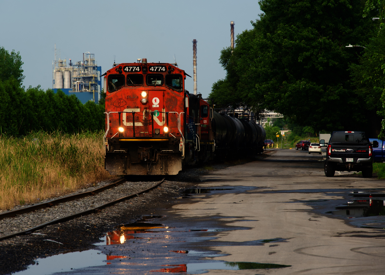 CN YRP002 is leaving Bitumar with eight cars as it parallels a quiet street.