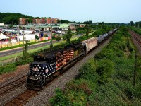 CPKC 528 with rear DPU KCS 4006 is passing a poutine festival on a smokey afternoon.