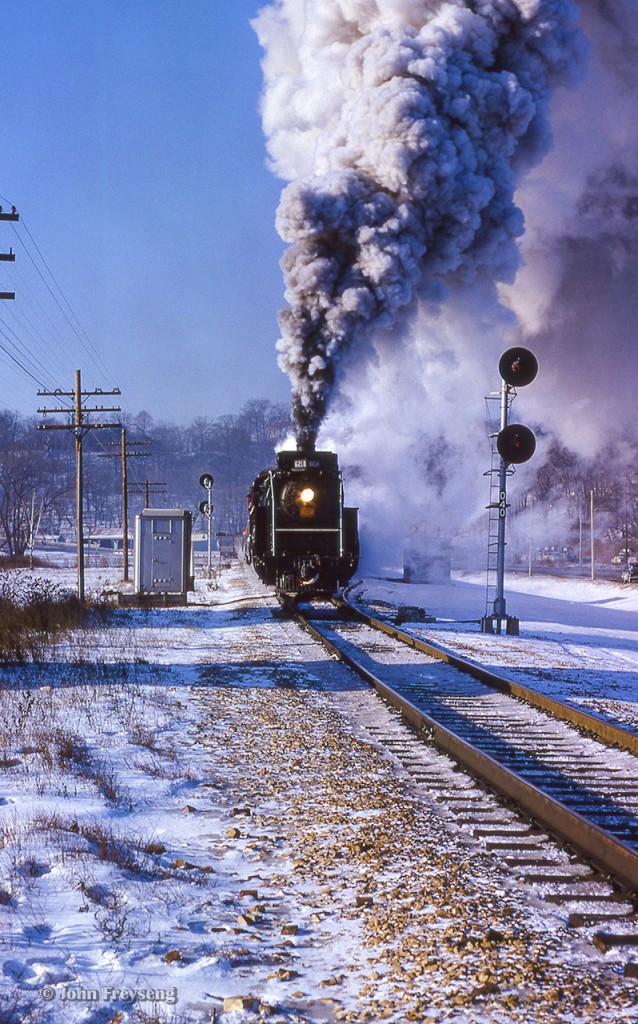 CNR 6218 works it's way north through the Don Valley, seen at the north switch for Rosedale siding.  This trip was part of the Upper Canada Railway Society's "Toronto Bypass" excursion, running up the Bala to Doncaster, west along the new York Subdivision to Mac Yard, continuing onto the Halton Subdivision to Burlington, and back to Toronto on the Oakville Sub.  Per the February 1965 newsletter, this was a trip of firsts:

"It was the first winter excursion for 6218, and the first time it had operated alone on an excursion in Ontario. The train was the first revenue passenger train over the York and Halton Subdivisions. It was the first time a steam engine had run between Doncaster and Halwest and the first time an engine of such size had run between Georgetown and Burlington. And, it was the first time that the Society had operated a steam excursion over a line that was not yet opened for regular service."


Standing across the Don River behind me, Steve Bradley captured this scene.


Scan and editing by Jacob Patterson.