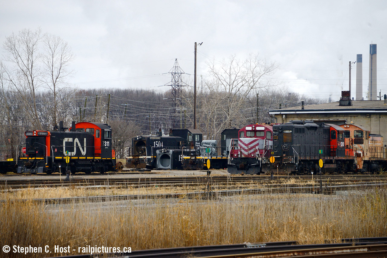 Pictured from the platform of the Sarnia VIA station is this motly collection of motive power at the Lambton Diesel Specialists shop located in the leased Sarnia CN roundhouse built around 1890. CN 7311 is the last CN SW1200 officially on the roster and leased to the CN Steel Center at Vaughan. It's shown here after repairs, waiting for pickup by a local which happened within an hour. 18 hours later it will be back in Toronto as it was lifted by 509 then taken to Toronto on 434 with no delay. A number of other LDS locomotives are shown: Former CN 4100 is now in GIO grey, the Stelco locomotive in behind is also painted now, and the two IC SW14's are currently being worked on as they were in this photo. The GP9 in the background bounces around and has already seen service at local industries.