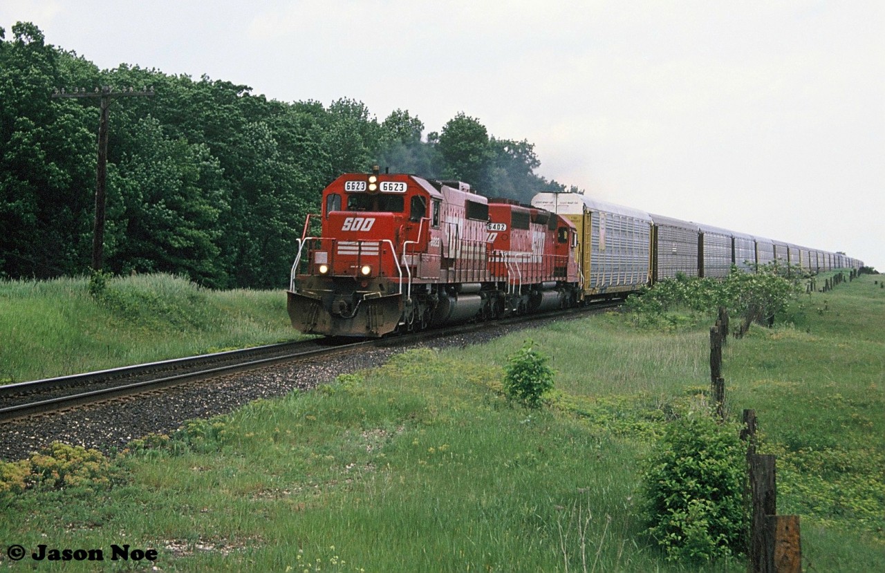 On a hazy and humid summer afternoon, SOO Line SD40-2 6623 and SD40 6402 are pictured heading westbound on the Galt Subdivision approaching Blenheim Road near what was the west end of Wolverton siding. SOO 6402 is former KCS 624.