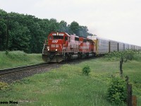 On a hazy and humid summer afternoon, SOO Line SD40-2 6623 and SD40 6402 are pictured heading westbound on the Galt Subdivision approaching Blenheim Road near what was the west end of Wolverton siding. SOO 6402 is former KCS 624.