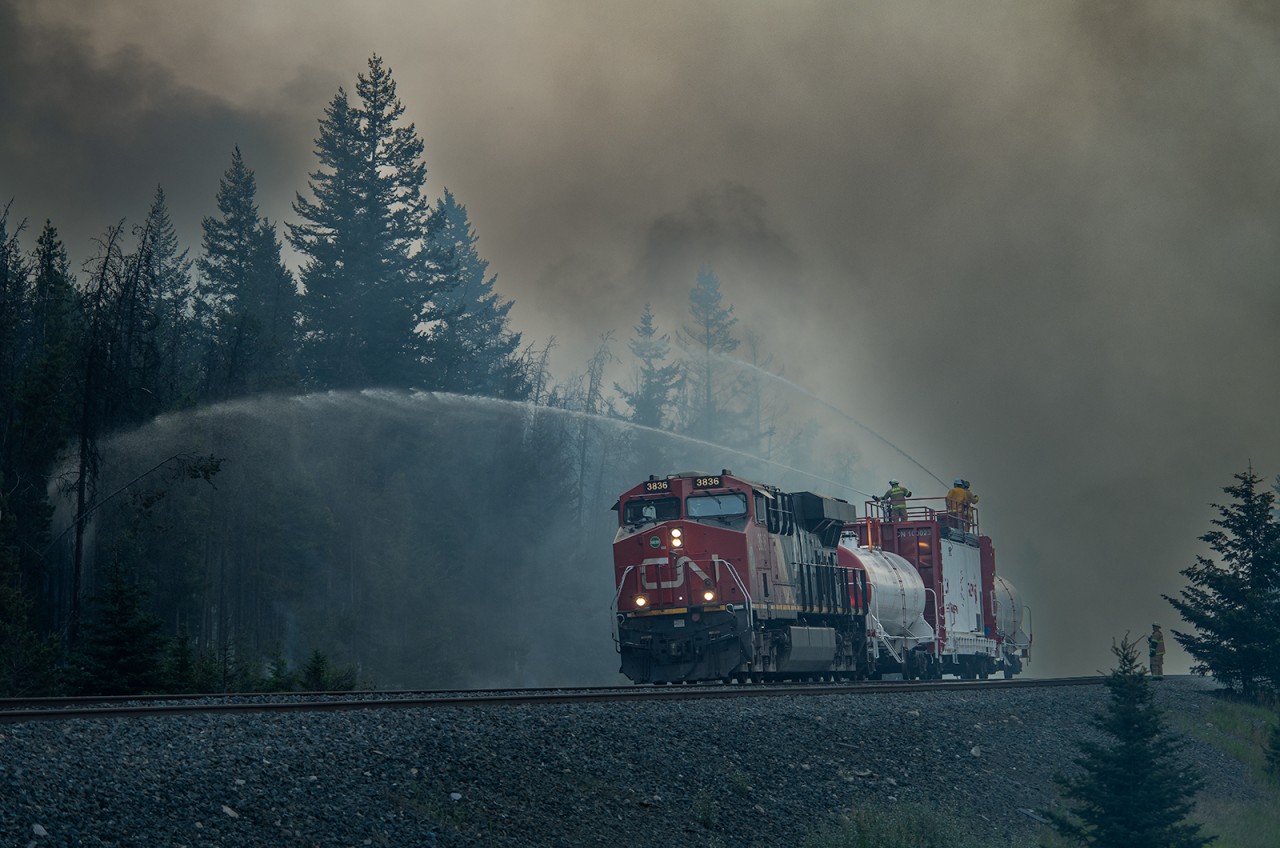 CN ES44AC 3836 shoves CN's "Trident" firefighting train eastward from Mile 231 on CN's Edson Sub to assist in battling the "North" fire of the Jasper Wildfire Complex.