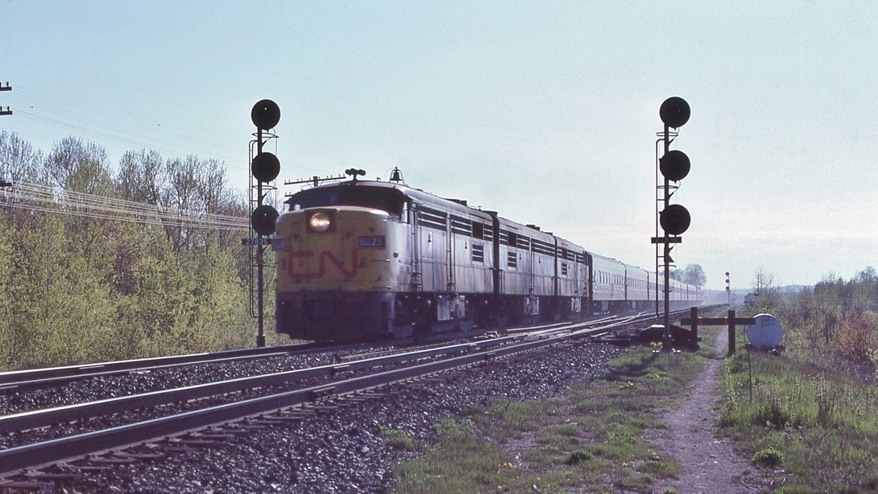 Ninety


Miles Per Hour Zone


Newtonville crossovers


VIA CN 6775 and two sisters....at track speed, 


Union Depot to Central Station, four intermediate passenger stops: five hours zero minutes.


Mile 278.3 Kingston Sub., May 13, 1979 Kodachrome by S.Danko.


Noteworthy: 


Second hand conventional equipment (hand me downs sold to VIA); 


1950's engineered rolling technologies (the 1958  FPA4's and the 1954  CC&F coaches), 


1940's signaling & engineered track (jointed rail),
 

and faster (time card) than today's billion $ Siemens Ventures....