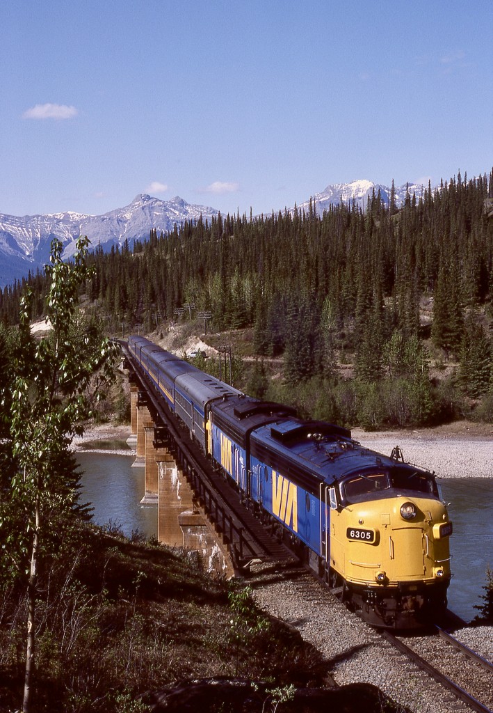 West of Edmonton, CN utilizes portions of Canadian Northern and Grand Trunk Pacific lines dating from the nineteen-teens railway construction mania that led to Canadian National being created.  West of Entrance, CN crossed the Athabasca River on a new (1926) alignment diverging from the GTP route around today’s mileage 190.8 to join the Canadian Northern route on the north side, with the CNoR route visible in this 1987-05-25 view of VIA No. 4 as the road to the right from the third passenger car.

Behind this train are stations Solomon and next Swan Landing, junction with the Alberta Resources Railway north to Grande Prairie.