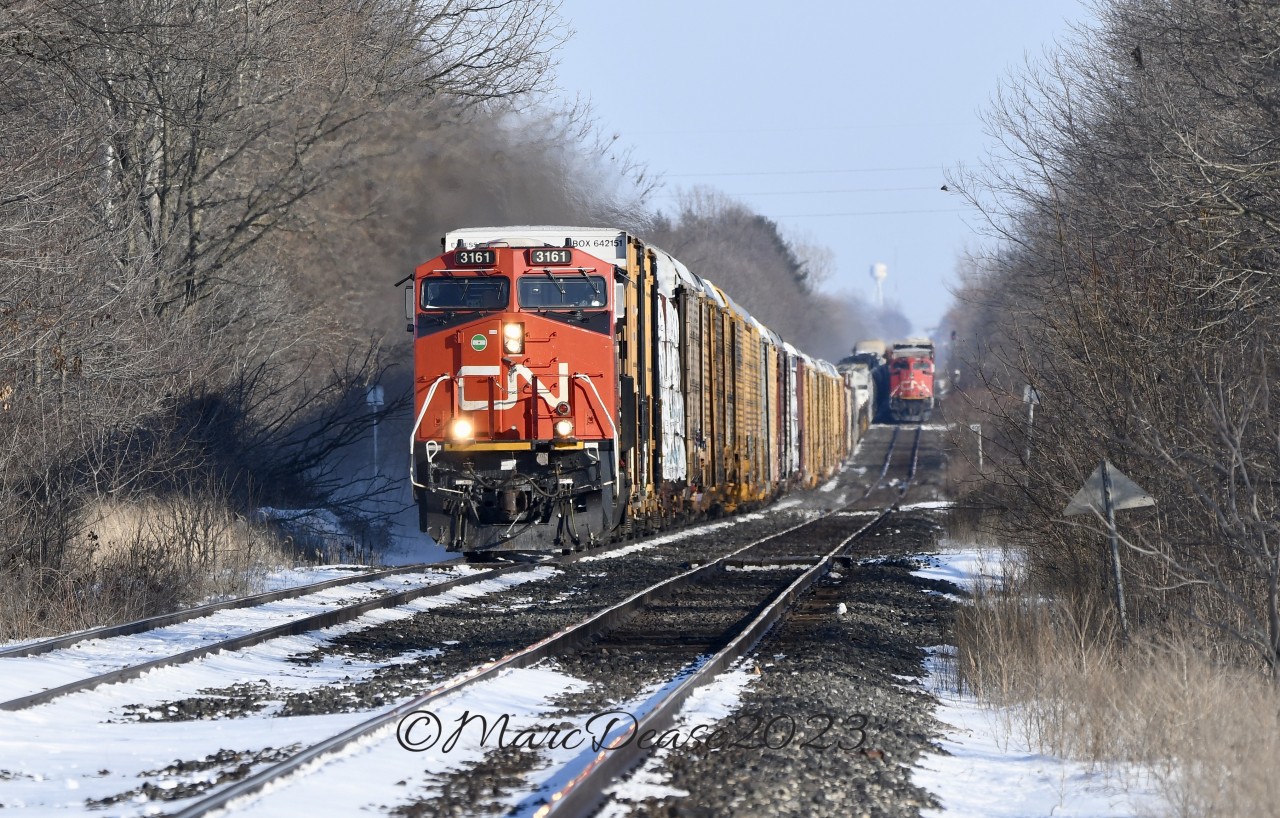 CN train 301 with CN 3161 in the lead overtakes train 385 at Stewardson Sideroad just east of Wanstead.