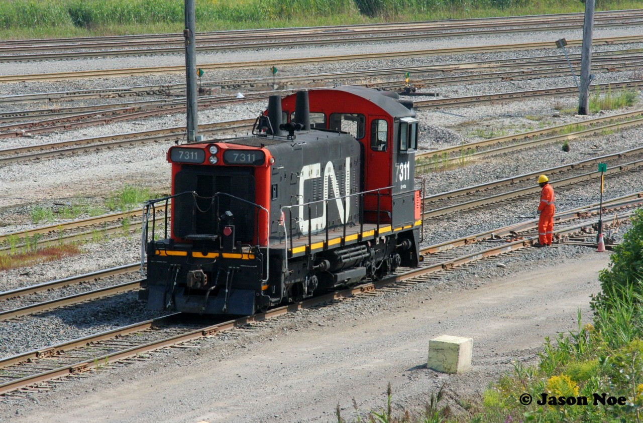 CN SW1200RSm 7311 is viewed pausing near the Highway #7 overpass at MacMillan Yard in Vaughn, Ontario. The crew had just re-aligned the switch and were preparing to head back into the yard after switching the newly built fuel transloading facility.