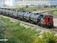 I would be lying if I said this one didn’t catch me by surprise. During my one visit this past August to the Highway #7 bridge that spans CN’s bustling MacMillan Yard in Vaughn, Ontario I spotted a CN switcher off in the distance deep within the yard. In 2023, CN had opened a new Cargoflo fuel transloading facility within the yard as well as constructed several storage tankers on site to store the fuel when unloaded. Situated off the W100 lead in the yard, CN had also built five tracks for this transload operation. Not long after my arrival on the bridge, the SW1200RSm came to life and began switching this facility. It’s been decades since I’ve photographed a CN switcher at MacMillan Yard, let alone working, so this was beyond cool to see in 2024. 
<br>
Here, CN SW1200RSm 7311 is viewed with a lengthy cut of tankers near the Highway #7 overpass with the fuel transloading facility in the background. Reportedly, both CN 7304 and 7311 are owned by a company under a CN subsidiary. However, only 7311 is the last remaining CN SW1200RSm on the current roster with its maintenance performed by CN at the MacMillan Yard Locomotive Reliability Center.
