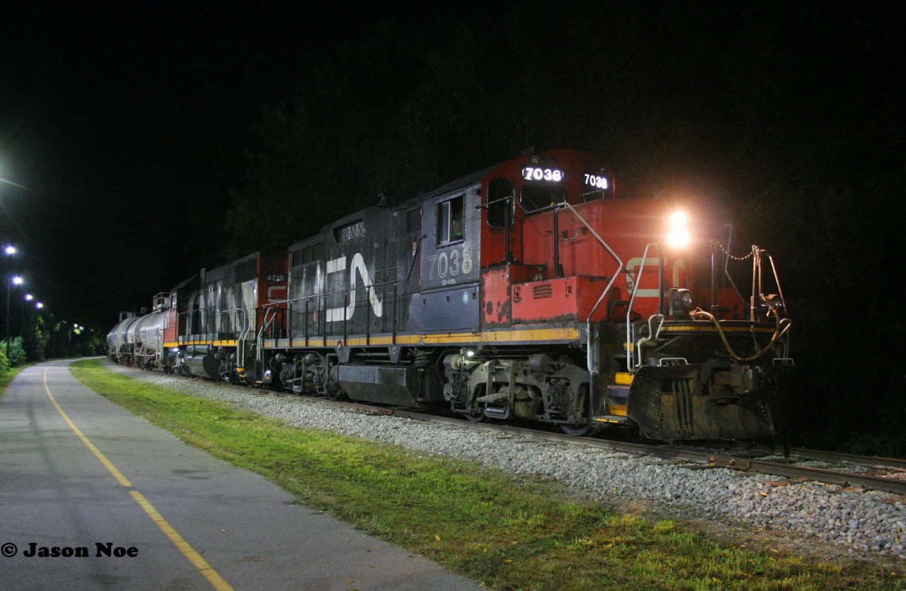 CN L566 with GP9RM 7038 and GP38-2 4716 and are viewed waiting near Roger Street in Waterloo, Ontario for permission to proceed north on the ION portion of the Waterloo Spur to Elmira.