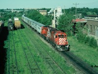 During a summer evening, the westbound CP Road Railer train 529 is viewed passing the east end of the yard in Galt, Ontario as it heads to London with a pair of multi-mark GP38-2’s. The tail-end of the train has just cleared the west siding switch Killean in the background. 