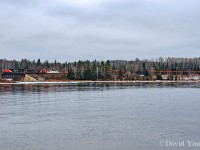 Seen looking across from the point on Mackenzie Bay along the shore of Lake Superior we see the second load of rail from the Kinghorn crossing over the mouth of the Mackenzie River. The white Operation Lifesaver caboose following CN 5713 and CN 2522 stands out against the stark and dull trees of a late northern Ontario, while the loaded train of rail just seems to blend in. Not the same effect as a mixed freight loaded with paper, lumber and the like but it will have to do. Rail removals crews would reach this location by July 2009 and have since made things much safer for area fisherman who like to fish beneath the bridge. They may not have the worry of trains to contend with anymore however when those that like to load 5 gallon buckets of smelt up in the springtime, its a long walk out without the support of the smooth rail to drag the heavy pails back to their vehicles.