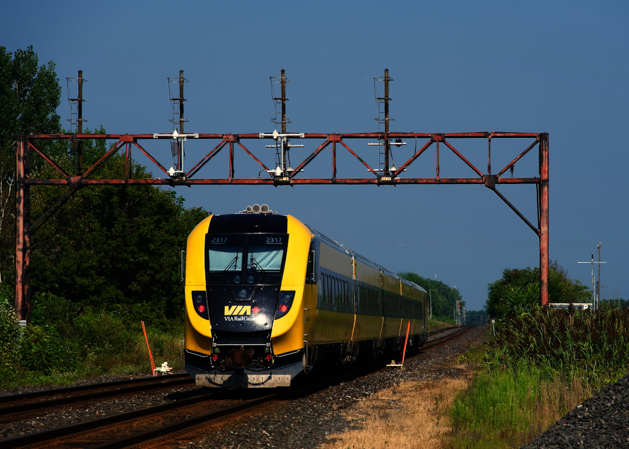 VIA 44 for Ottawa has the specially painted Lumi trainset as it passes under an out of use signal gantry.