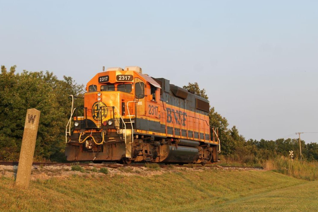 A BNSF unit is heading towards Blenheim, ON on a CN local, returning horsepower hours to CN. They would lift 15 cars and head back to Chatham after. Noted in the photo is an old whistle sign that is still barely standing.