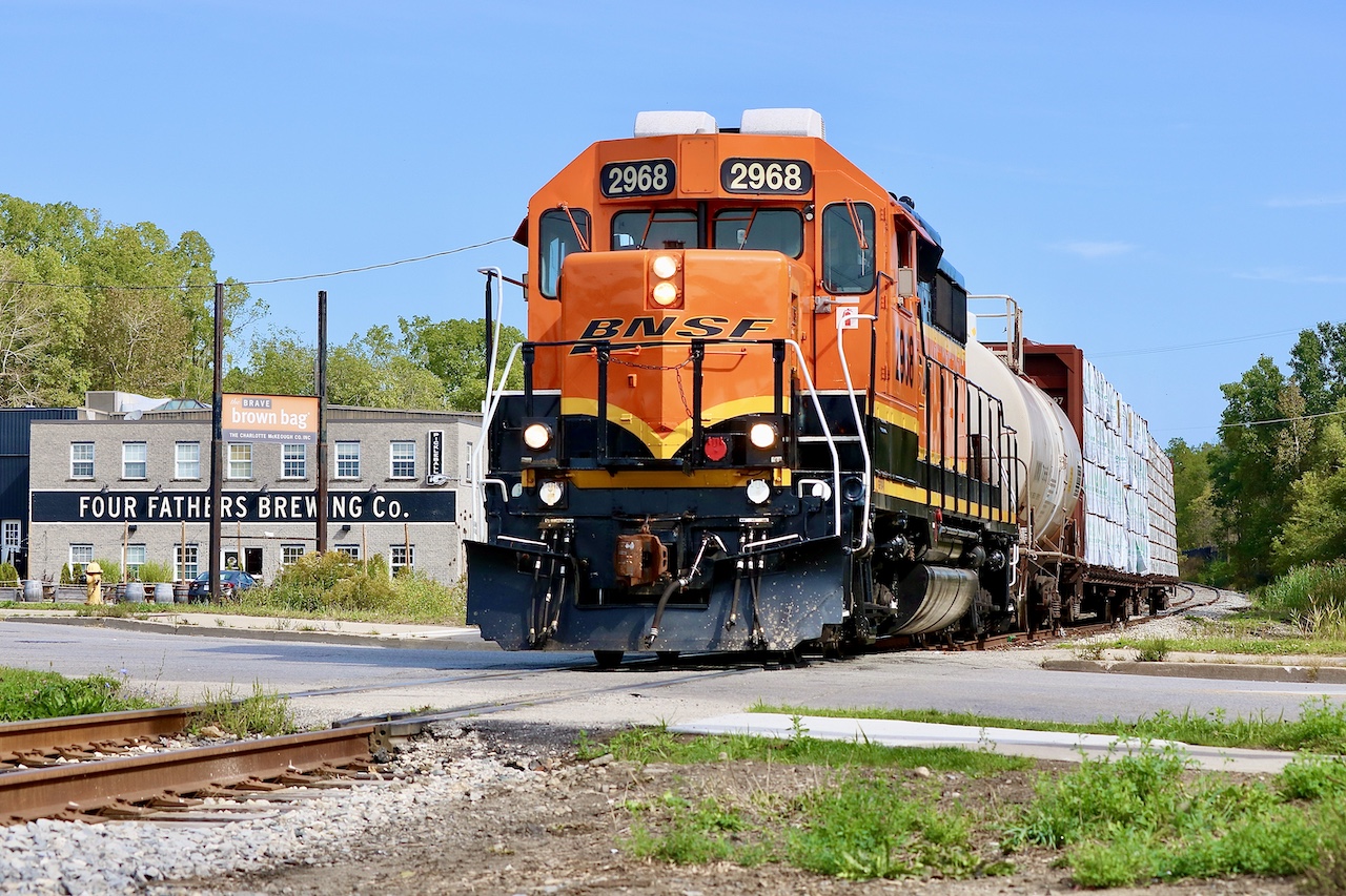 Props certainly help to make the scene sometimes. I’ve always loved all the old factories in Hespeler, even if the majority have been repurposed. My hopes today were simply to find BNSF 2968 and grab a few photos, especially as I’m not sure how long the BNSF Gerps will be sticking around. After no luck finding it in Guelph I decided to check the Fergus spur. As luck would have it they were finishing up at the chemical facility south of Guelph and had lumber loads for Preston in tow. Great lighting made for a nice slow chase and some decent shots. Here solo BNSF GP39V 2968 passes Four Fathers Brewing company as they enter  Hespeler with three cars in tow.