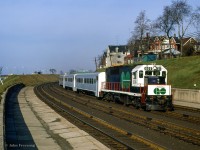 GO Transit GP40TC 606 brings up the rear of train 905, the 0700 departure from Pickering to Oakville, passing the old Exhibition station, located between Dufferin Street and Jameson Avenue.  This station, only consisting of two platforms, was opened in 1912 to serve the annual Canadian National Exhibition at the nearby Exhibition grounds, replacing <a href=https://www.trha.ca/trha/history/stations/exhibition-station/>an earlier station</a> nearby.  It continued to see use until 1968, when the new Exhibition GO station was opened east of Dufferin Street, on the site of the original Exhibition station.  These platforms would see one more bit of service foir the 1979 CNE due to crowding at Exhibition GO, with this location being temporarily named "Dufferin Gates." Since then, the old platforms have remained abandoned and overgrown, with stairs to Dufferin Street fenced off.<br><br><i>Scan and editing by Jacob Patterson.</i>